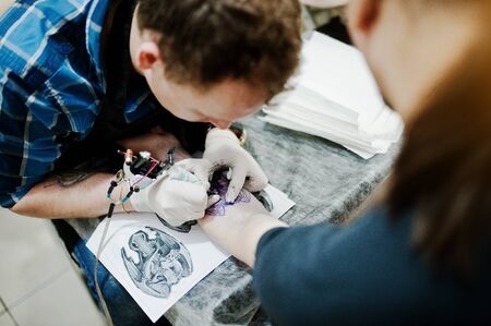 Tattoo master make tattoo for rocker man at tattoo salonの写真素材