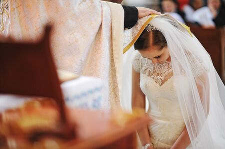 Priest puts hand the blessings of bride