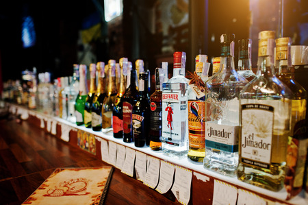 KYIV, UKRAINE - MARCH 25, 2016: Various alcoholic beverages bottles in the bar. Beefeater London dry gin in the center.のeditorial素材