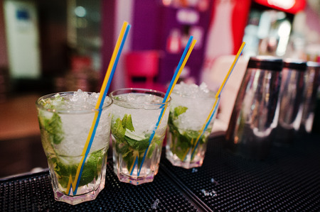 Three mojito coctail drink with colored tubes at the barの写真素材