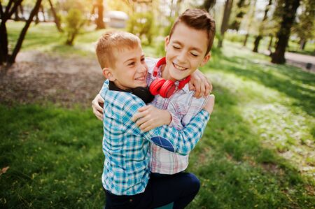 Two brother boy with headphones having fun on park. Brother love.の写真素材
