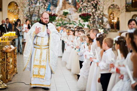 LVIV, UKRAINE - MAY 8, 2016: Priest at ceremony of a First Communion in the Church of St. Peter the...