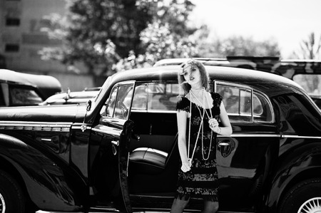 Portrait of beautiful sexy curly fashion girl model with bright makeup in retro style near vintage carの写真素材