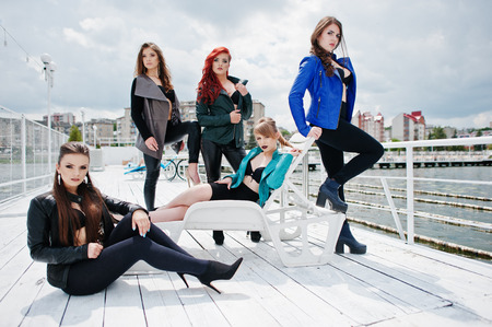 Group of sexy models girls in black bra and leather jackets on the dockの写真素材