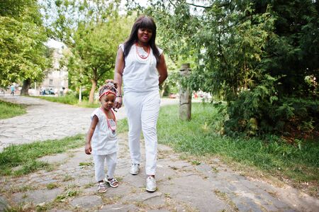 African american mother with daughter walking at parkの写真素材