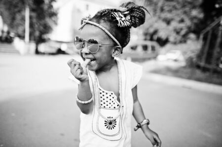 Amazing beautiful african american baby girl with sunglasses having funの写真素材