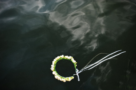 Wreath with white roses and ribbon on watherの写真素材