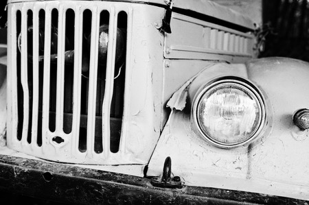 Retro car headlight with radiator grille. Black and white photo