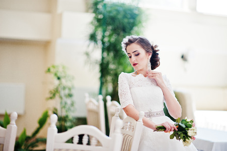 Portrait of beautiful bride at wedding hall near chairs and tableの写真素材