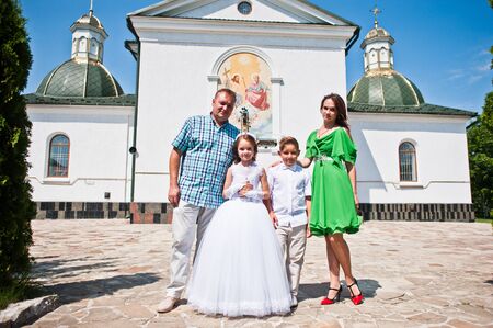 Happy family at first holy communion background church