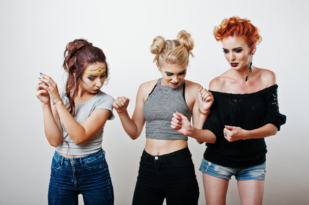 Fashion studio portrait of three funny girls with bright make upの写真素材