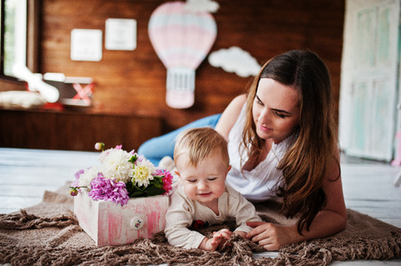 Young happy mother with son lying on plaid blanket