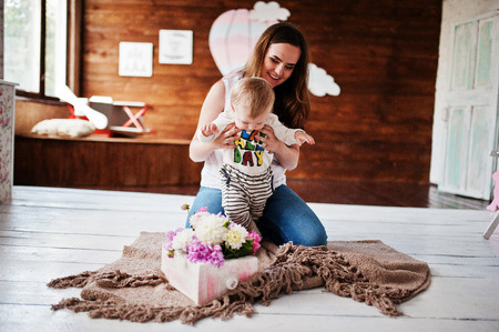 Young happy mother with son lying on plaid blanket