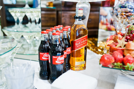 Hai, Ukraine - October 25, 2016: Coca Cola bottle with Red Label whiskey on buffet tableのeditorial素材