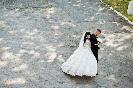 View from above of stylish wedding couple on road at park.の写真素材