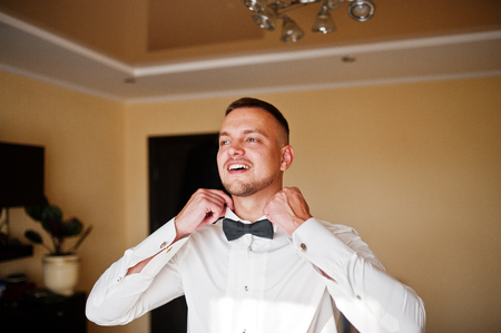 Man wearing bow tie on shirt. Gathering of groom on wedding day.の写真素材