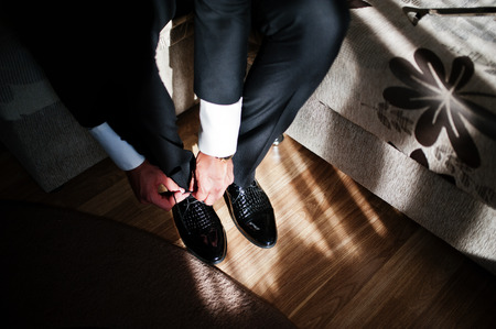 Man wearing luxury patent leather shoes on sunlight with shadows. Gathering of groom on wedding day.の写真素材