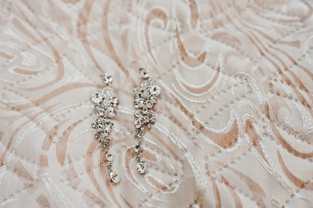 Elegancy wedding brilliant earrings of bride on texture.の写真素材