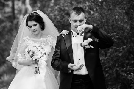 Wedding couple stay at forest. Groom throw rings on air. Black and white photoの写真素材