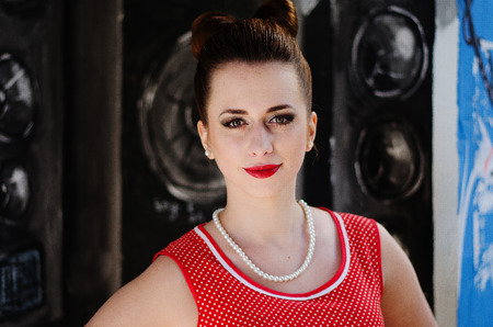 Close up portrait of young pinup girl wearing at retro vintage old-fashioned dress in peas, retro...
