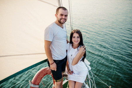 Young beautiful married couple in love at the yacht on vacation.