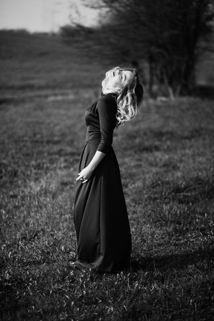 Yong elegance blonde girl at green dress on the garden in spring.の写真素材