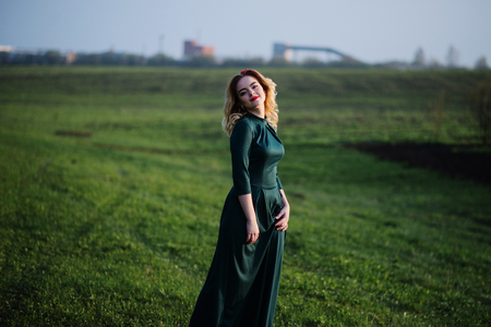 Yong elegance blonde girl at green dress on the garden in spring.の写真素材