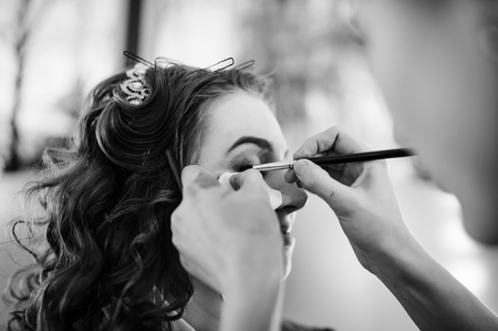 Beautiful young bride with wedding makeup and hairstyle preparation for wedding. Black and white photo.の写真素材