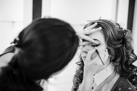 Beautiful young bride with wedding makeup and hairstyle preparation for wedding. Black and white photo.の写真素材