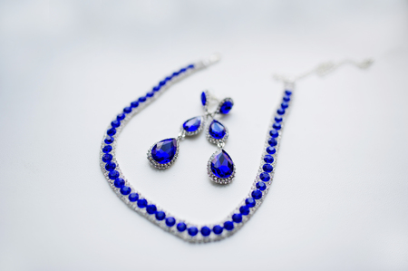 Blue necklace and earrings on white background at morning of bride.の写真素材