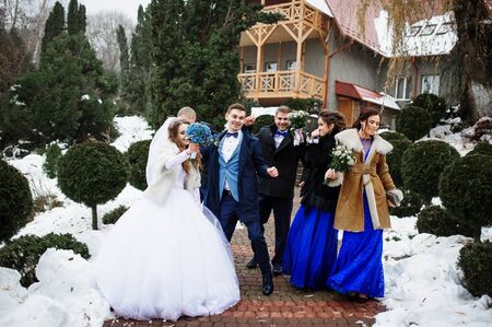 Wedding couple with bridesmaids and best mans have fun on winter day.の写真素材