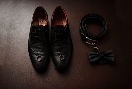 Brown leather men's shoes with accessories and wedding rings. Set of groom.の写真素材
