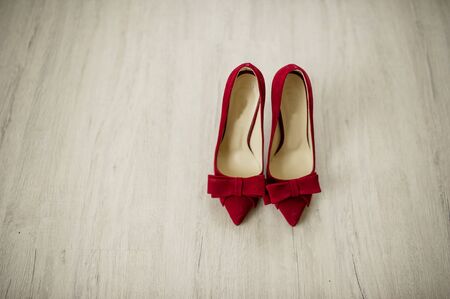 Red velvet bride shoes on wooden background.の写真素材