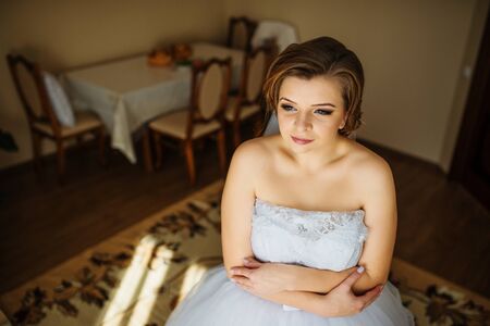 Young bride posed at her room in morning wedding.の写真素材