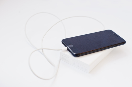 Hai, Ukraine - February 28, 2017:  Apple Iphone 7 charged from Xiaomi power bank 20000 mah isolated on white background.のeditorial素材