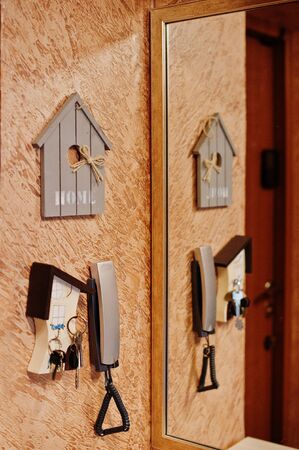 Intercom with keys and mirror near home entrance.
