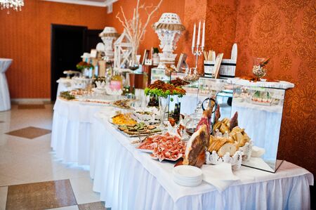 Royal elegance wedding reception table with different cookery food.の写真素材