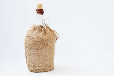 Bottle at sack material isolated on white.の写真素材