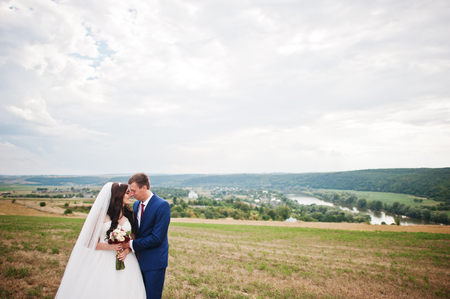 Wedding couple in love stay at beautiful landscape with river on background.の写真素材
