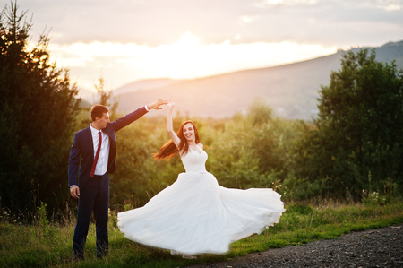 Lovely wedding couple against sunset at Carpathian mountains.の写真素材