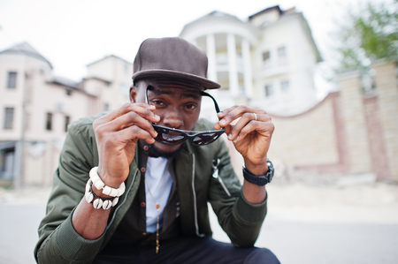 Close up portrait of stylish african american man wear on sunglasses and cap outdoor. Street fashion black man.の写真素材