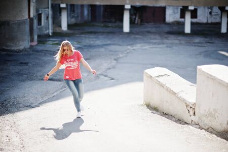 Stylish happy blonde woman wear at jeans, sunglasses and t-shirt posed at street on sunny weather....