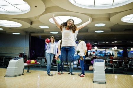 Group of girls having fun and play bowling at hen party.