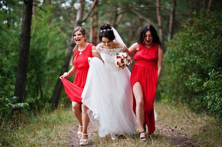 Fantastic bride with awesome bridesmaids having fun in the forest on a wedding day.の写真素材