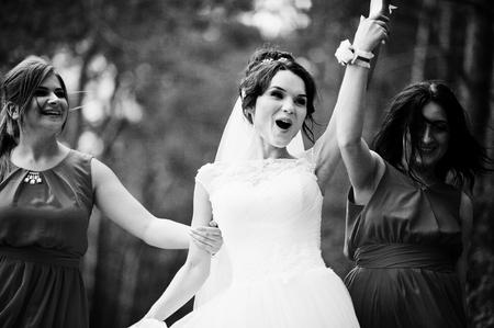 Fantastic bride with awesome bridesmaids having fun in the forest on a wedding day. Black and white photo.の写真素材