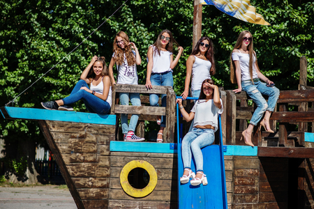 Six fabulous girl faving fun posing on a childish wooden ship in the park.の写真素材
