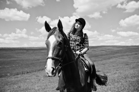 Young pretty girl riding a horse in the field.の写真素材
