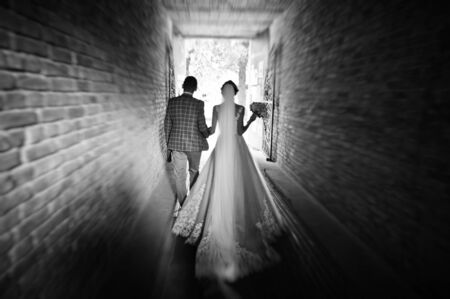 Flawless wedding young couple walking on city streets on a sunny day. Black and white photo.の写真素材