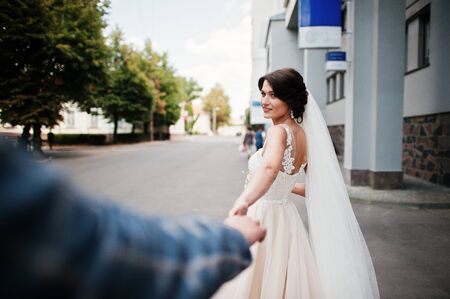 Flawless wedding young couple walking on city streets on a sunny day.の写真素材