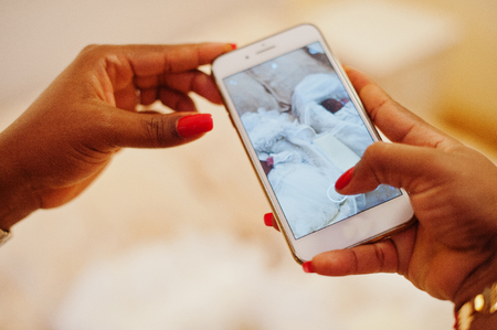 Close-up photo of a woman taking picture of a newborm african american baby.の写真素材